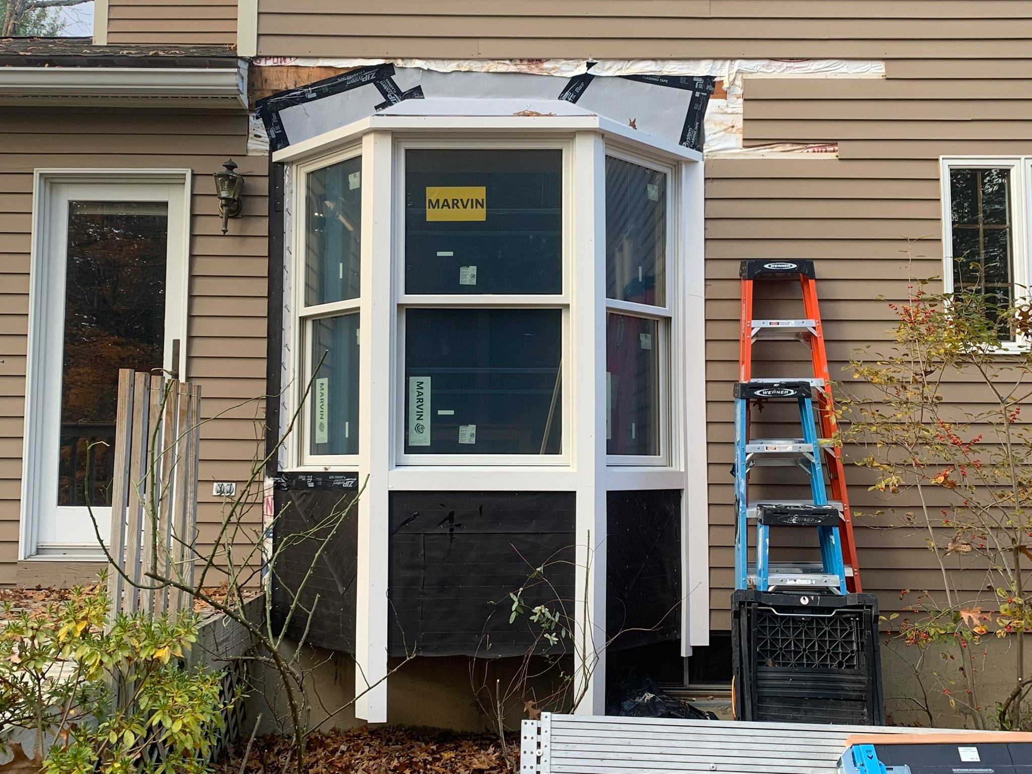 Marvin bay window freshly installed — rough opening with flashing tape visible