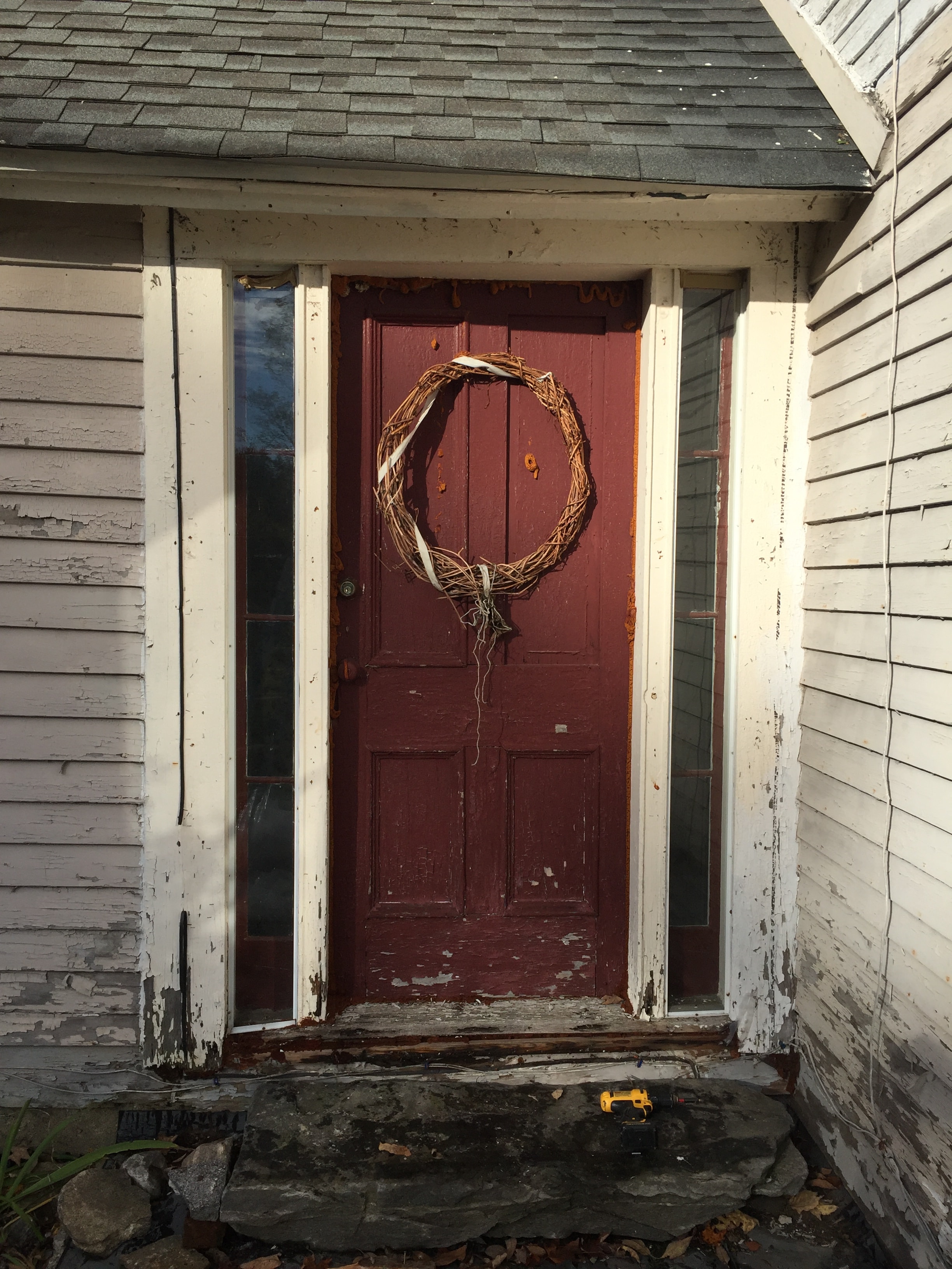 Entry door before replacement — peeling red paint and deteriorated trim