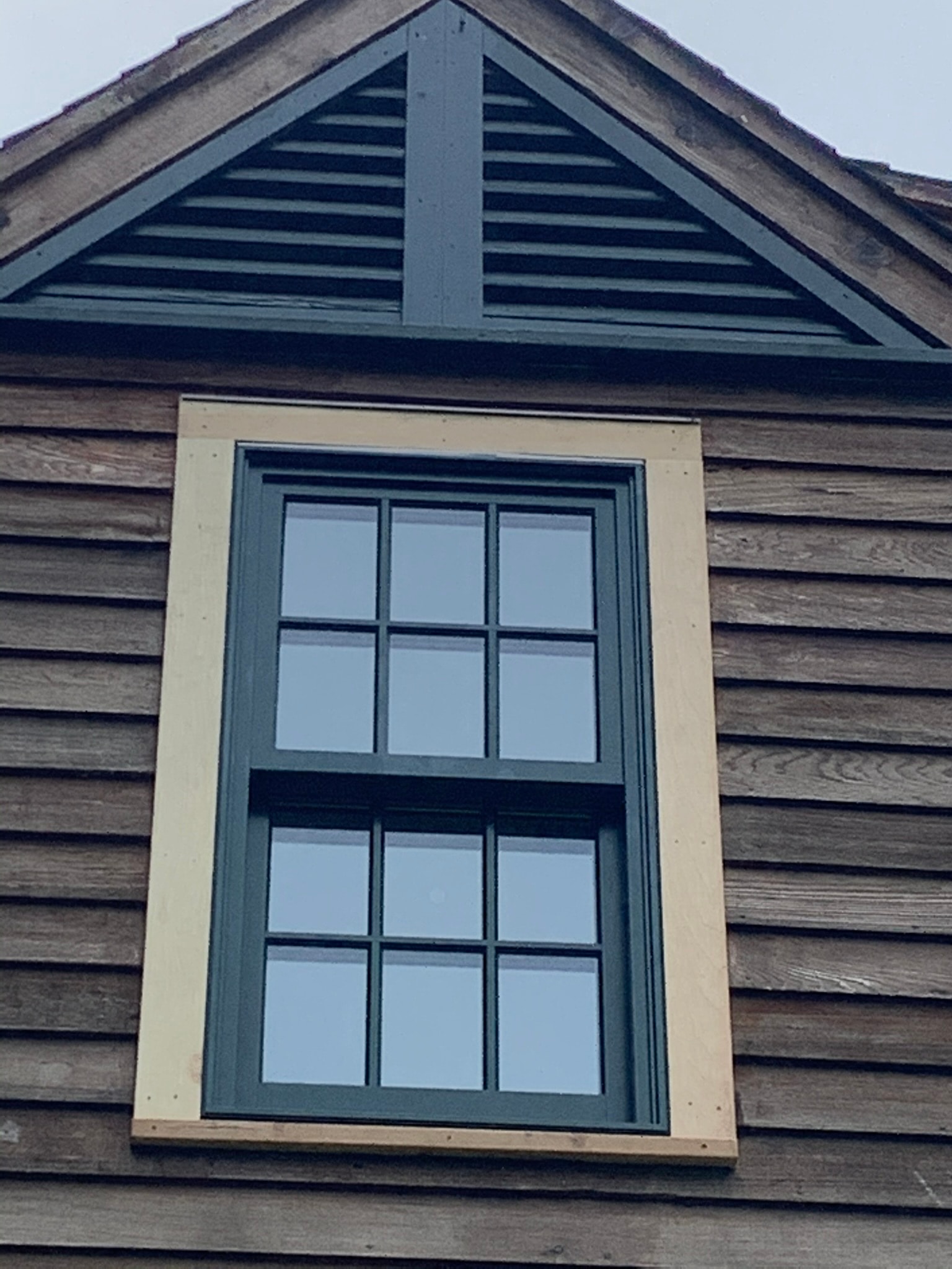 Marvin double-hung window installed on dark cedar-clad gable