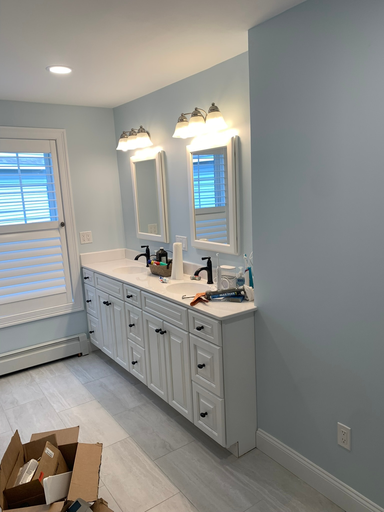 2nd floor bathroom — dual vanity with white cabinetry, quartz countertop, black fixtures, and tile floor