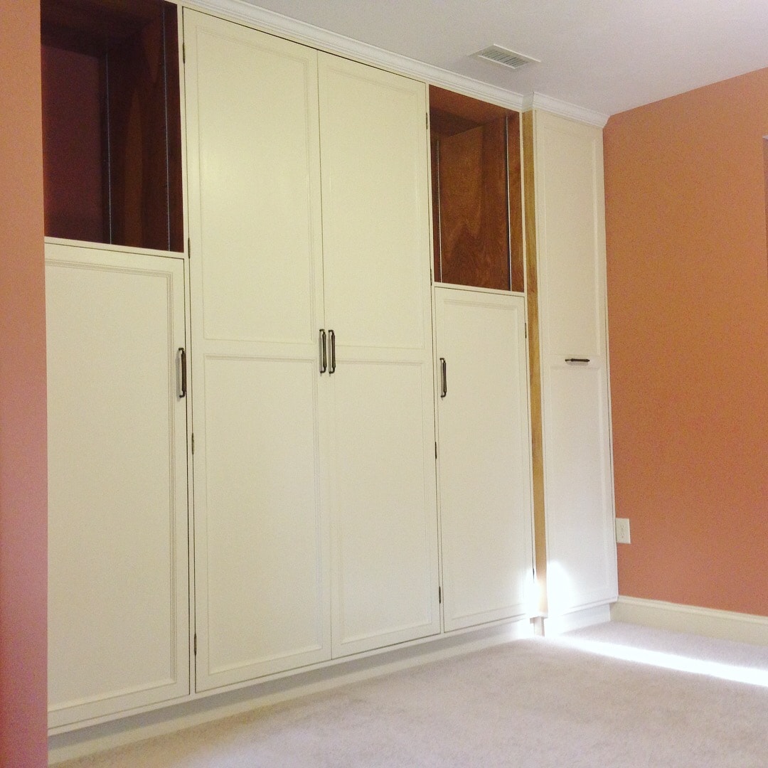 Custom built-in wall-to-wall cabinetry — finished view with cream painted doors and open upper shelving