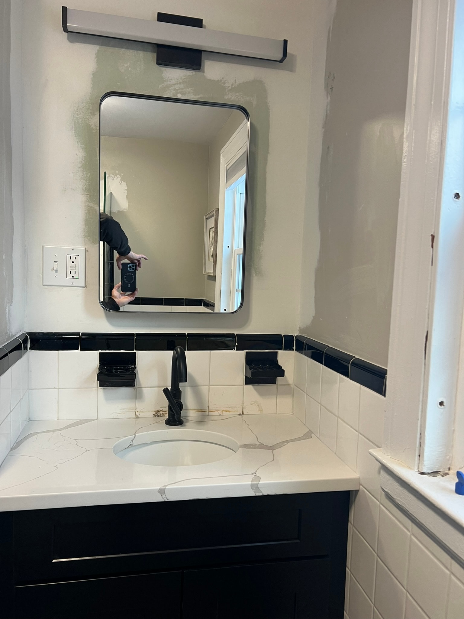 New black shaker vanity with calacatta quartz custom top, matte black faucet, recessed mirror, and vanity light bar — classic bathroom update Eastern Connecticut