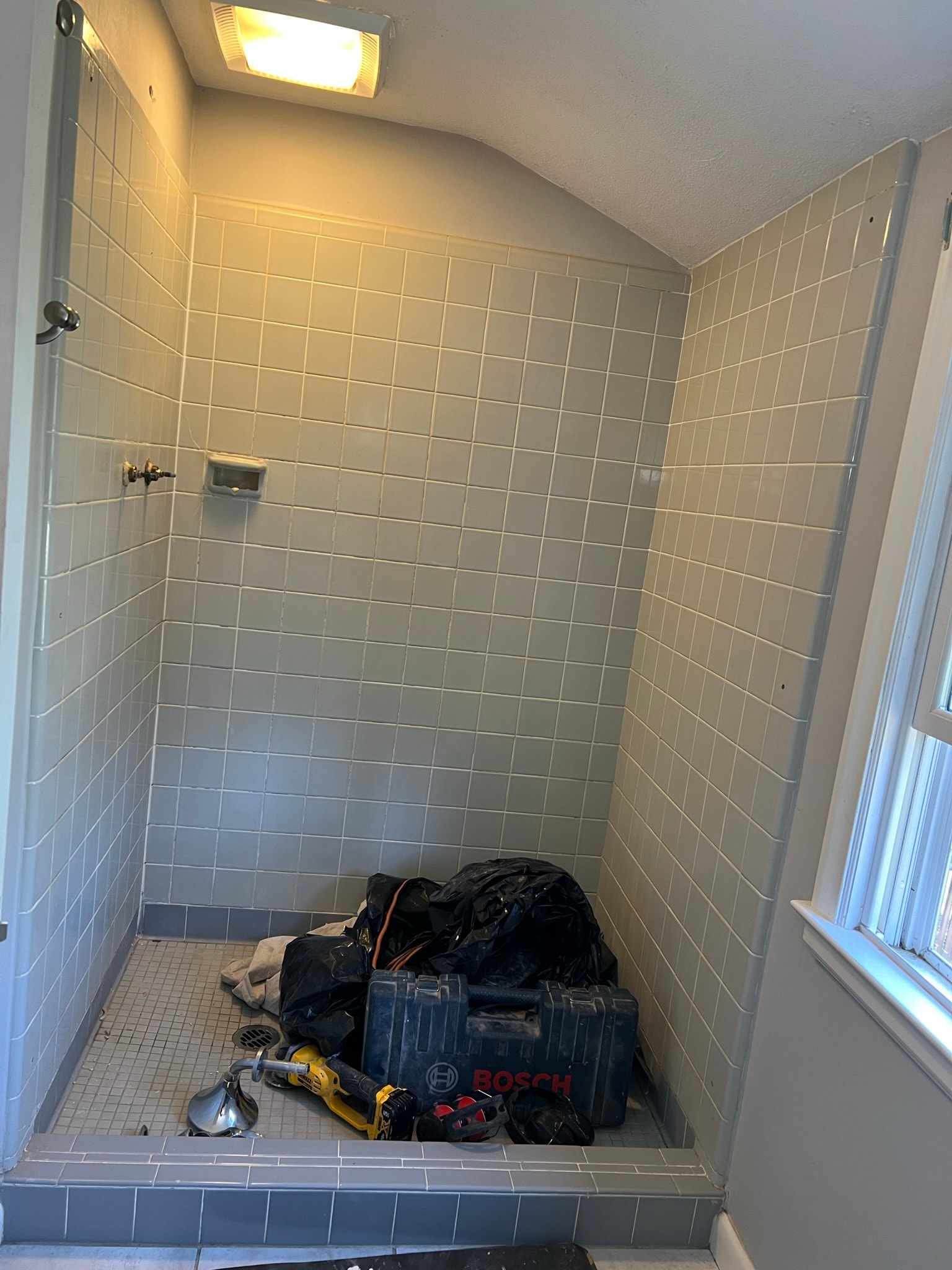 Before — shower stall mid-construction with custom mud-set pan formed and mosaic tile floor pan in progress