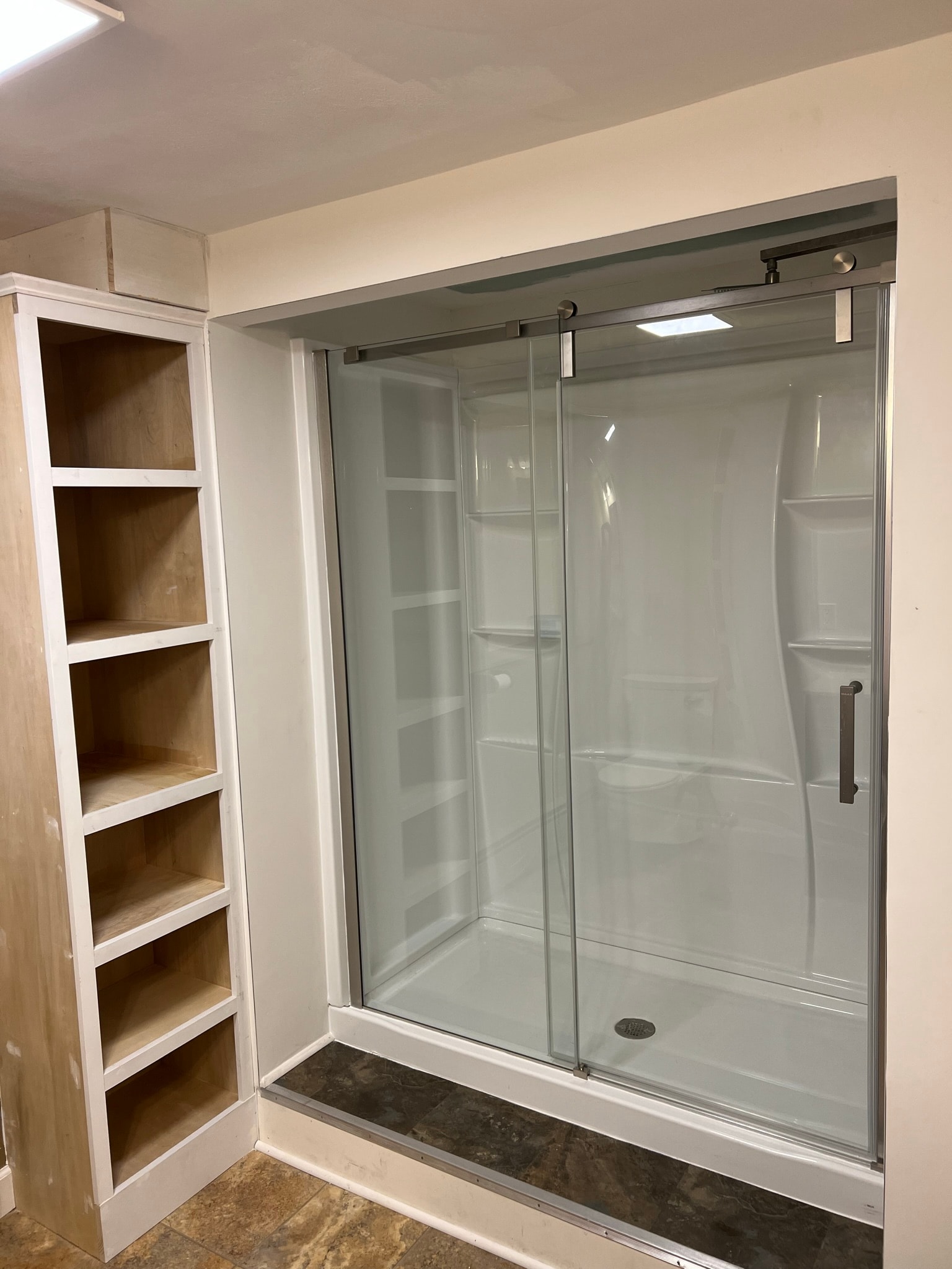 Finished full bath conversion — new sliding glass door shower installed on previously blank wall