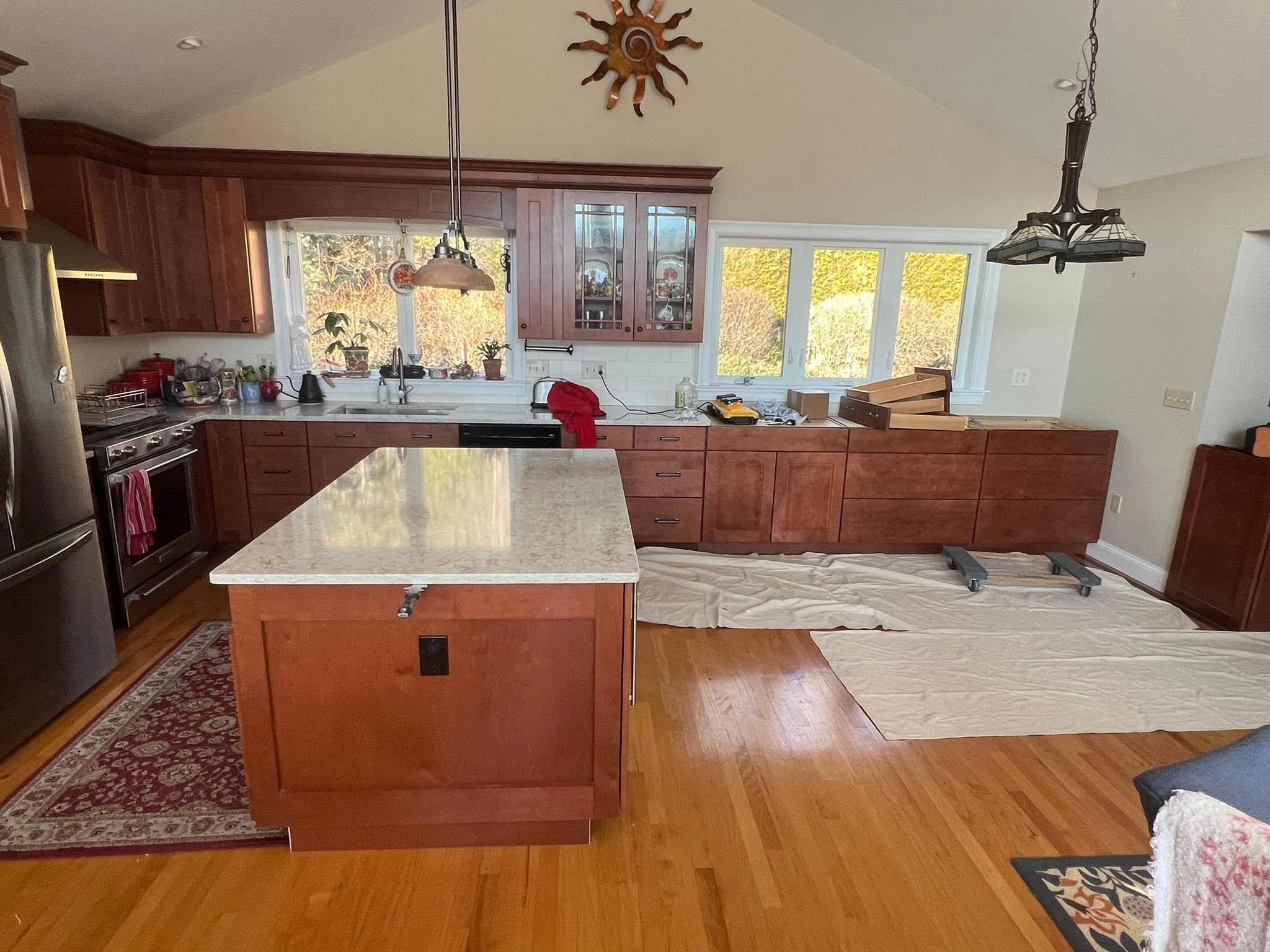 Before — existing cherry shaker kitchen with island in original orientation, lower cabinets staged for reconfiguration — Eastern Connecticut