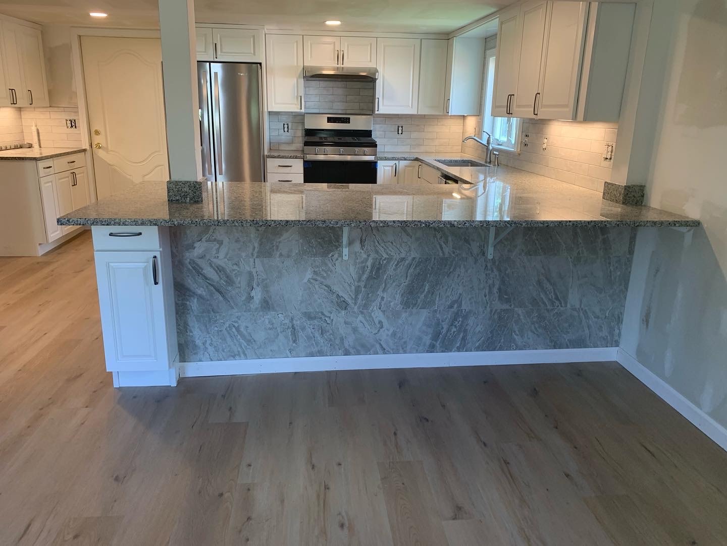 Modern kitchen renovation with marble waterfall island