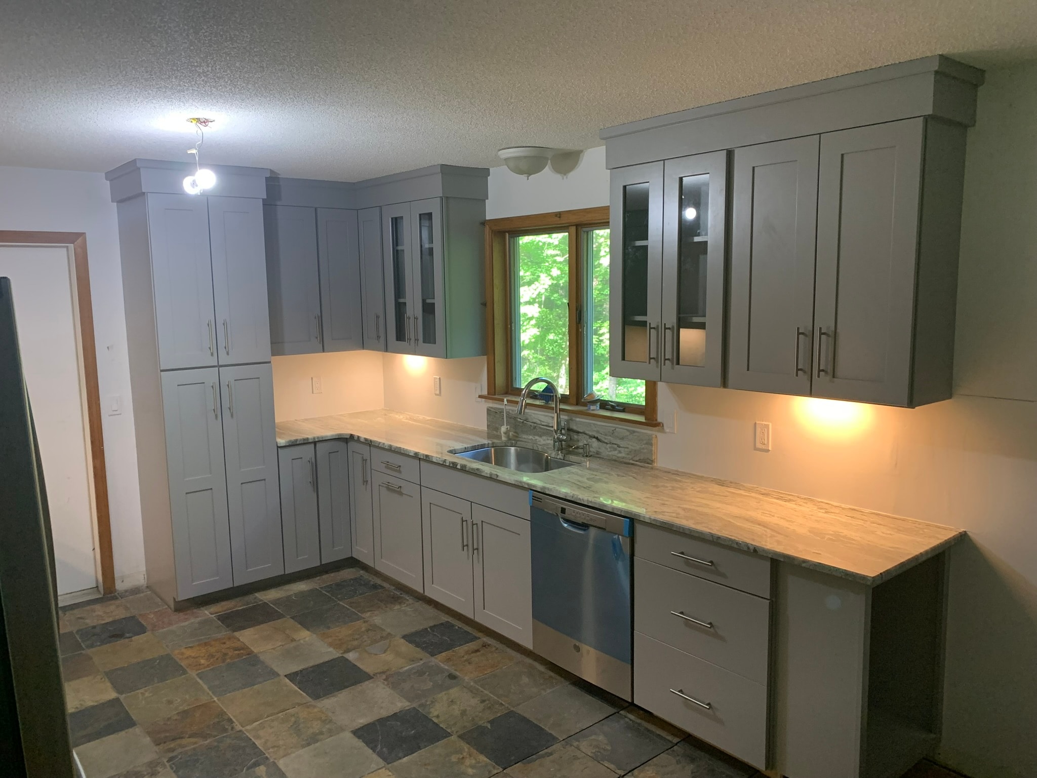 Completed kitchen renovation — gray shaker cabinets, marble countertops, slate tile floor, and stainless appliances, Eastern Connecticut
