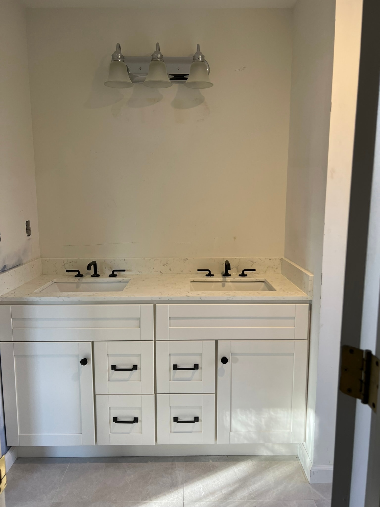 White shaker dual vanity with marble countertop, dual undermount sinks, and matte black faucets — bathroom remodel in Eastern Connecticut