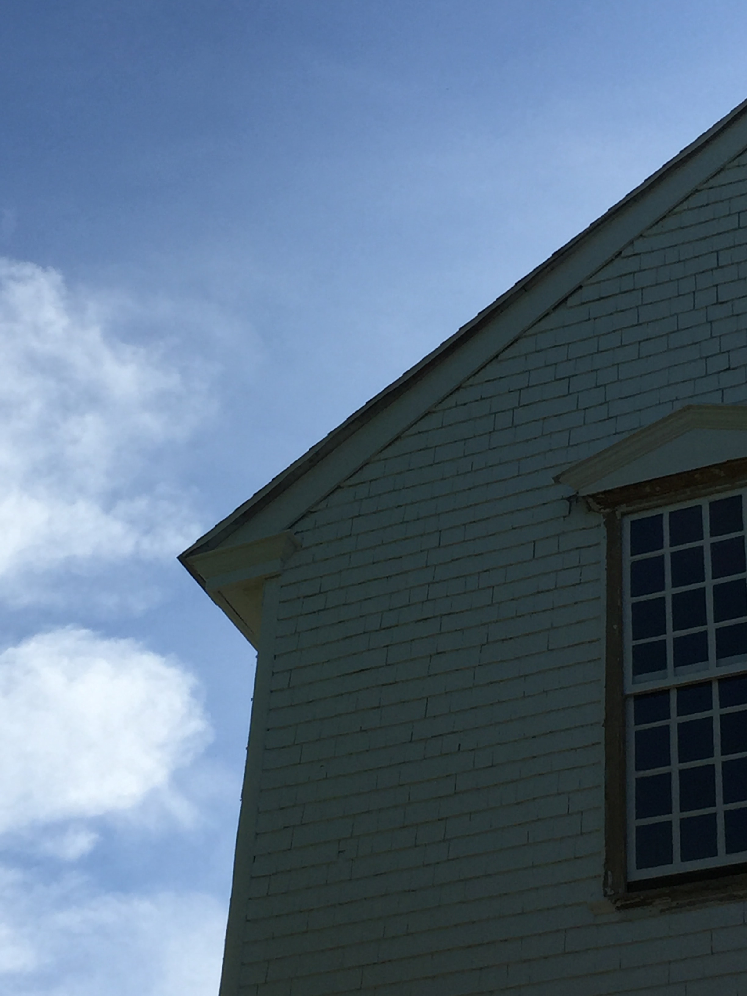 Cherry picker lift work on historic white clapboard steeple restoration